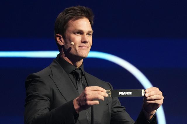 US Draw assistant Tom Brady shows the card reading France during the draw for the 2026 FIFA Football World Cup taking place in the US, Canada and Mexico, at the Kennedy Center, in Washington, DC, on December 5, 2025. (Photo by Stephanie Scarbrough / POOL / AFP)