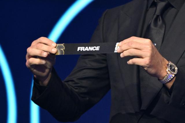US Draw assistant Tom Brady shows the card reading France during the draw for the 2026 FIFA Football World Cup taking place in the US, Canada and Mexico, at the Kennedy Center, in Washington, DC, on December 5, 2025. (Photo by Mandel NGAN / POOL / AFP)