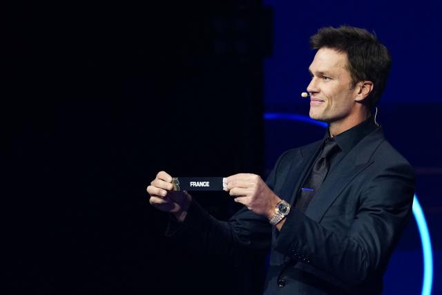 US Draw assistant Tom Brady shows the card reading France during the draw for the 2026 FIFA Football World Cup taking place in the US, Canada and Mexico, at the Kennedy Center, in Washington, DC, on December 5, 2025. (Photo by Jia Haocheng / POOL / AFP)