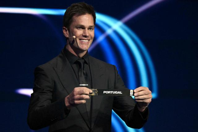 US football player Tom Brady shows the card reading Portugal during the draw for the 2026 FIFA Football World Cup taking place in the US, Canada and Mexico, at the Kennedy Center, in Washington, DC, on December 5, 2025. (Photo by Jim WATSON / AFP)