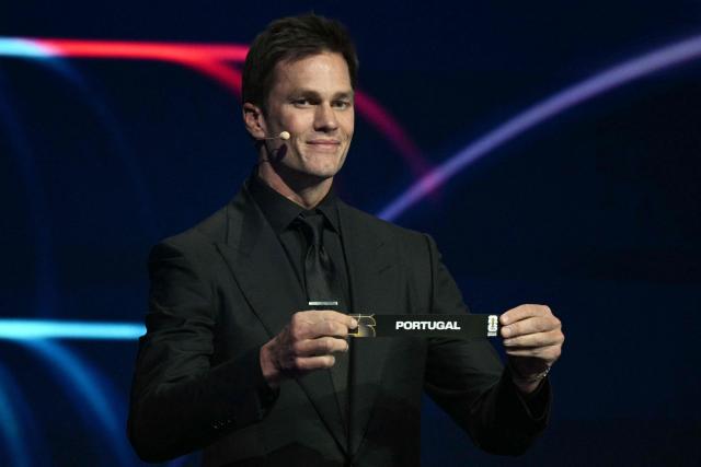 US football player Tom Brady shows the card reading Portugal during the draw for the 2026 FIFA Football World Cup taking place in the US, Canada and Mexico, at the Kennedy Center, in Washington, DC, on December 5, 2025. (Photo by Jim WATSON / AFP)