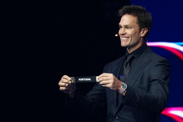 US Draw assistant Tom Brady shows the card reading France during the draw for the 2026 FIFA Football World Cup taking place in the US, Canada and Mexico, at the Kennedy Center, in Washington, DC, on December 5, 2025. (Photo by Jia Haocheng / POOL / AFP)