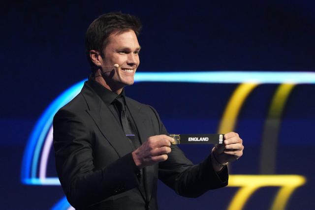 US Draw assistant Tom Brady shows the card reading England during the draw for the 2026 FIFA Football World Cup taking place in the US, Canada and Mexico, at the Kennedy Center, in Washington, DC, on December 5, 2025. (Photo by Stephanie Scarbrough / POOL / AFP)