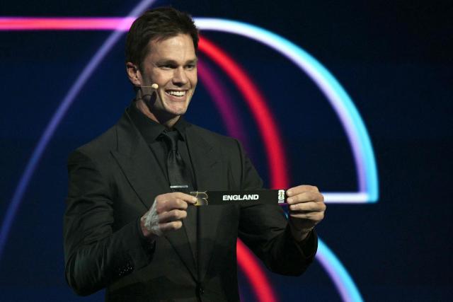 US football player Tom Brady shows the card reading England during the draw for the 2026 FIFA Football World Cup taking place in the US, Canada and Mexico, at the Kennedy Center, in Washington, DC, on December 5, 2025. (Photo by Jim WATSON / AFP)