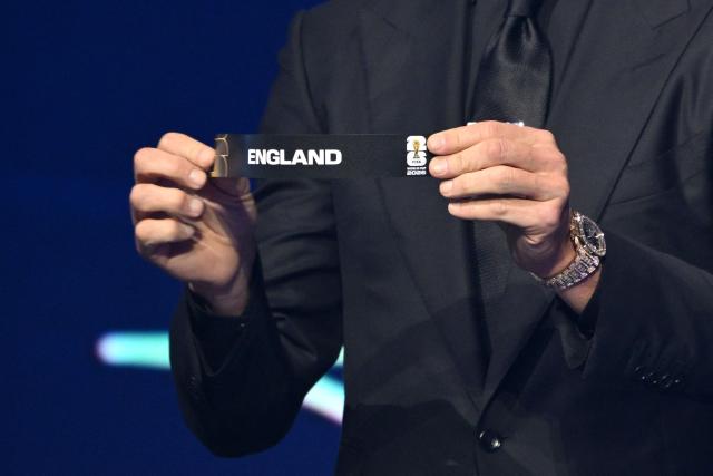 US Draw assistant Tom Brady shows the card reading England during the draw for the 2026 FIFA Football World Cup taking place in the US, Canada and Mexico, at the Kennedy Center, in Washington, DC, on December 5, 2025. (Photo by Mandel NGAN / POOL / AFP)