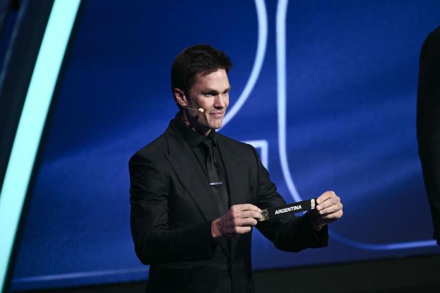 US Draw assistant Tom Brady shows the card reading Argentina during the draw for the 2026 FIFA Football World Cup taking place in the US, Canada and Mexico, at the Kennedy Center, in Washington, DC, on December 5, 2025. (Photo by Brendan SMIALOWSKI / AFP)