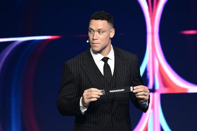 US Draw assistant Aaron Judge shows the card reading Paraguay during the draw for the 2026 FIFA Football World Cup taking place in the US, Canada and Mexico, at the Kennedy Center, in Washington, DC, on December 5, 2025. (Photo by Brendan SMIALOWSKI / AFP)