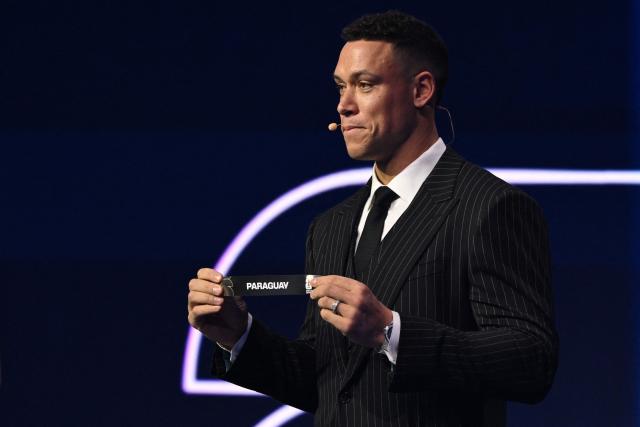 US Draw assistant Aaron Judge shows the card reading Paraguay during the draw for the 2026 FIFA Football World Cup taking place in the US, Canada and Mexico, at the Kennedy Center, in Washington, DC, on December 5, 2025. (Photo by Mandel NGAN / POOL / AFP)