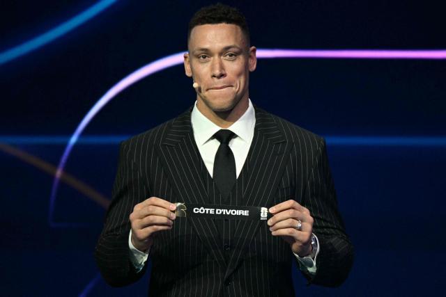 US baseball player Aaron Judge shows the card reading Ivory Coast during the draw for the 2026 FIFA Football World Cup taking place in the US, Canada and Mexico, at the Kennedy Center, in Washington, DC, on December 5, 2025. (Photo by Jim WATSON / AFP)
