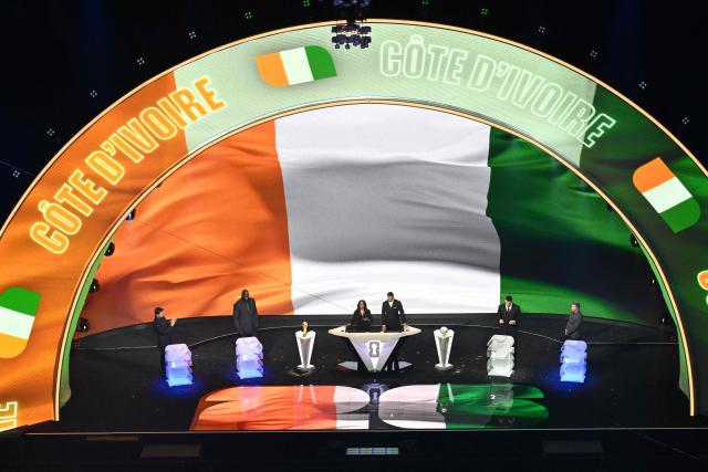 Ivory Coast's flag is displayed on a screen during the draw for the 2026 FIFA Football World Cup taking place in the US, Canada and Mexico, at the Kennedy Center, in Washington, DC, on December 5, 2025. (Photo by Roberto SCHMIDT / AFP)