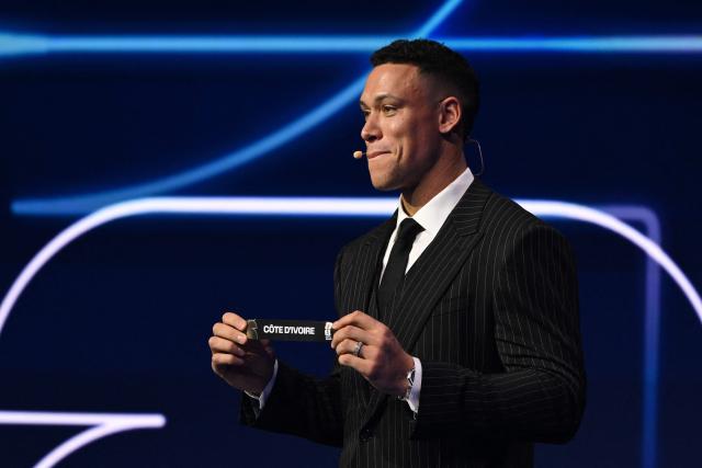 US Draw assistant Aaron Judge shows the card reading Cote D'Ivoire during the draw for the 2026 FIFA Football World Cup taking place in the US, Canada and Mexico, at the Kennedy Center, in Washington, DC, on December 5, 2025. (Photo by Mandel NGAN / POOL / AFP)