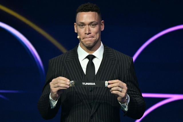 US baseball player Aaron Judge shows the card reading Tunisia during the draw for the 2026 FIFA Football World Cup taking place in the US, Canada and Mexico, at the Kennedy Center, in Washington, DC, on December 5, 2025. (Photo by Jim WATSON / AFP)
