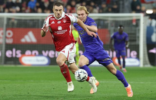 Brest's French defender #05 Brendan Chardonnet (L) and Monaco's Danish forward #14 Mika Biereth fight for the ball during the French L1 football match between Stade Brestois 29 (Brest) and AS Monaco at the Francis-Le-Ble stadium in Brest, western France, on December 5, 2025. (Photo by Fred TANNEAU / AFP)