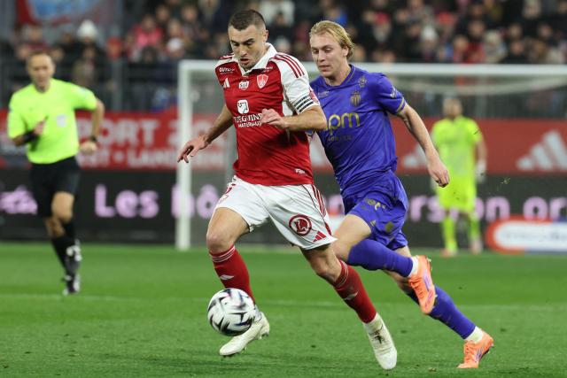 Brest's French defender #05 Brendan Chardonnet (C) and Monaco's Danish forward #14 Mika Biereth fight for the ball during the French L1 football match between Stade Brestois 29 (Brest) and AS Monaco at the Francis-Le-Ble stadium in Brest, western France, on December 5, 2025. (Photo by Fred TANNEAU / AFP)