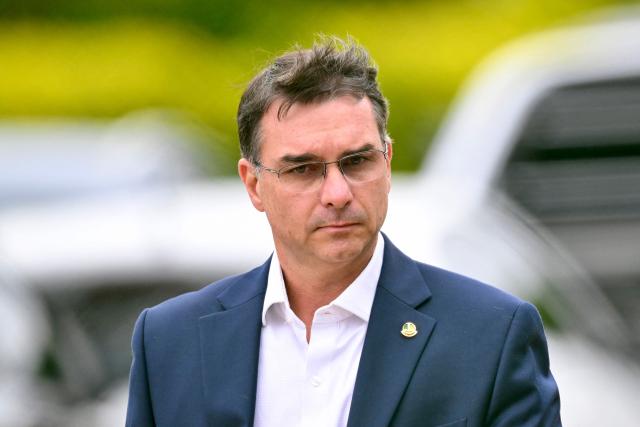 (FILES) Senator Flavio Bolsonaro, son of former Brazilian president Jair Bolsonaro, leaves the Federal Police headquarters where Bolsonaro is being held, in Brasilia, on November 25, 2025. The eldest son of former Brazilian President Jair Bolsonaro, Senator Flavio Bolsonaro, said on December 5, 2025 that his father had designated him as his political heir, less than a year before the presidential elections in the South American giant. (Photo by Evaristo Sa / AFP)