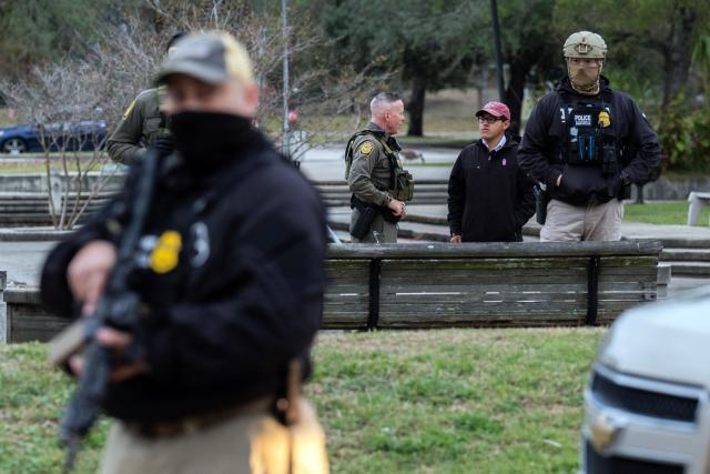 US Customs and Border Patrol Commander Gregory Bovino (C-L) interviews resident Julio Rosas, as he's backed by fellow agents during an immigration raid at a park in Metairie, Louisiana, on December 5, 2025. The US Department of Homeland Security announced on December 3 it has launched a federal immigration enforcement operation, named "Operation Catahoula Crunch," in the New Orleans, Louisiana, area. (Photo by Adam GRAY / AFP)
