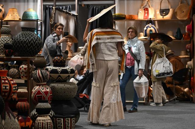 Women attend Expoartesanias Fair, which highlights artisans work and their ancestral creations in Bogota on December 5, 2025. (Photo by Raul ARBOLEDA / AFP)