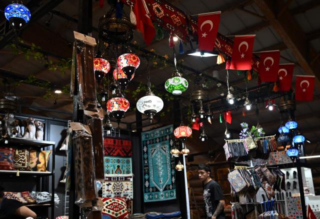 A man attends Expoartesanias Fair, which highlights artisans work and their ancestral creations in Bogota on December 5, 2025. (Photo by Raul ARBOLEDA / AFP)