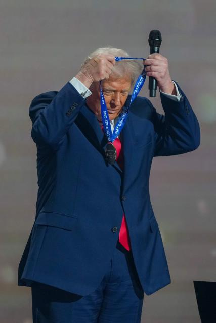 US President Donald Trump puts on a medal as he receives the FIFA Peace Prize from FIFA President Gianni Infantino during the draw for the 2026 FIFA Football World Cup taking place in the US, Canada and Mexico, at the Kennedy Center, in Washington, DC, on December 5, 2025. (Photo by Stephanie Scarbrough / POOL / AFP)