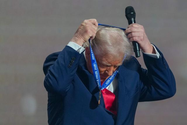 US President Donald Trump receives the FIFA Peace Prize from FIFA President during the draw for the 2026 FIFA Football World Cup taking place in the US, Canada and Mexico, at the Kennedy Center, in Washington, DC, on December 5, 2025. (Photo by Stephanie Scarbrough / POOL / AFP)
