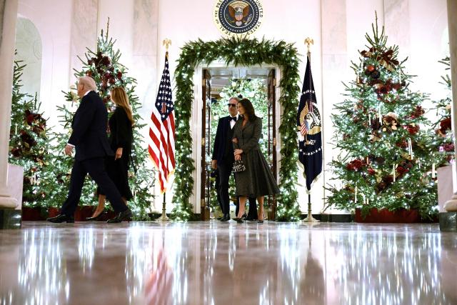US President Donald Trump (L), First Lady Melania Trump (2-L) and guests arrive to attend a concert by Andrea Bocelli in the East Room of the WHite House in Washington, DC on December 5, 2025. (Photo by Brendan SMIALOWSKI / AFP)