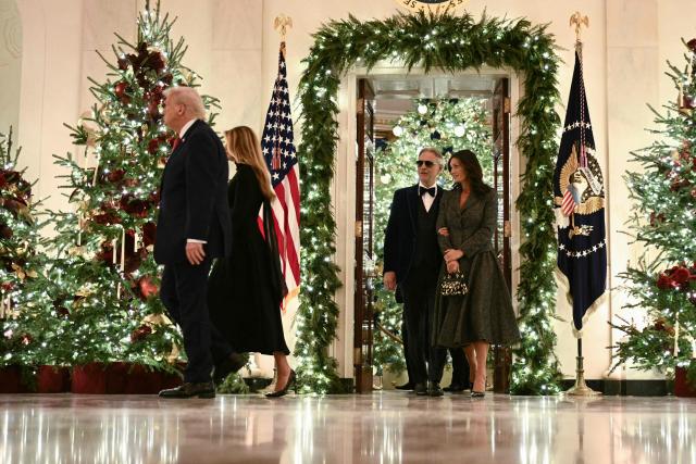 US President Donald Trump and First Lady Melania Trump followed by Italian tenor Andrea Bocelli and his wife Veronica Berti arrive in the East Room of the White House where Bocelli will perform, in Washington, DC on December 5, 2025. (Photo by Brendan SMIALOWSKI / AFP)