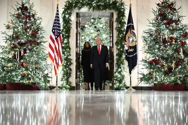 US President Donald Trump and First Lady Melania Trump  arrive in the East Room of the White House to attend a concert by Italian tenor Andrea Bocelli in Washington, DC on December 5, 2025. (Photo by Brendan SMIALOWSKI / AFP)