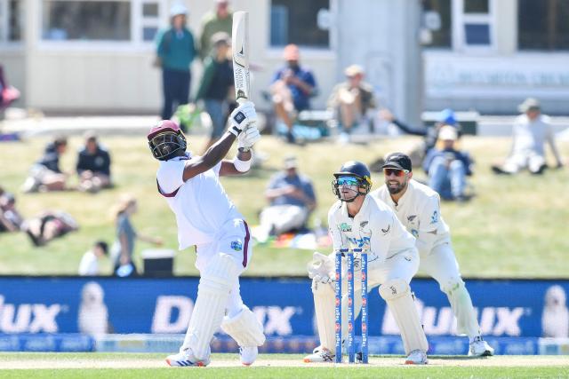 West Indies' Kemar Roach (L) bats in front of New Zealand's wicketkeeper Tom Latham (C) and Daryl Mitchell during day five of the first Test cricket match between New Zealand and West Indies at Hagley Oval in Christchurch on December 6, 2025. (Photo by Sanka Vidanagama / AFP)