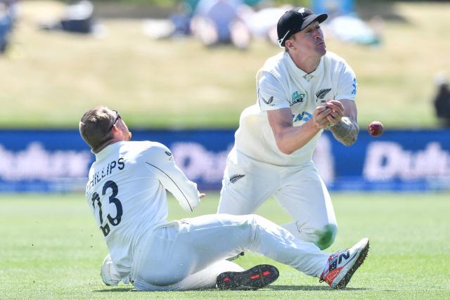New Zealand's Blair Tickner (R) drops a catch off West Indies' Kemar Roach next to Glenn Phillip during day five of the first Test cricket match between New Zealand and West Indies at Hagley Oval in Christchurch on December 6, 2025. (Photo by Sanka Vidanagama / AFP)
