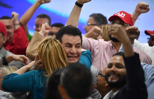 Salvador Nasralla, presidential candidate for the opposition Liberal Party, is embraced by supporters in Tegucigalpa on December 5, 2025. Hondurans waited on December 5, 2025, for results from a tight presidential race held five days earlier, with a technical tie persisting between Asfura, a right-wing candidate favored by US President Donald Trump, and the candidate for the Liberal Party Nasralla. (Photo by Orlando SIERRA / AFP)