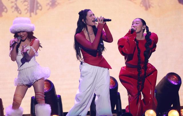 (L-R) Singers Rei Ami, Ejae and Audrey Nuna from the band HUNTR/X perform on stage during the KIIS FM's iHeartRadio Jingle Ball 2025 at the Inuit Dome in Inglewood, California on December 4, 2025. (Photo by Michael Tran / AFP)