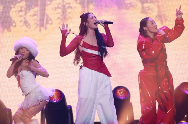 (L-R) Singers Rei Ami, Ejae and Audrey Nuna from the band HUNTR/X perform on stage during the KIIS FM's iHeartRadio Jingle Ball 2025 at the Inuit Dome in Inglewood, California on December 4, 2025. (Photo by Michael Tran / AFP)