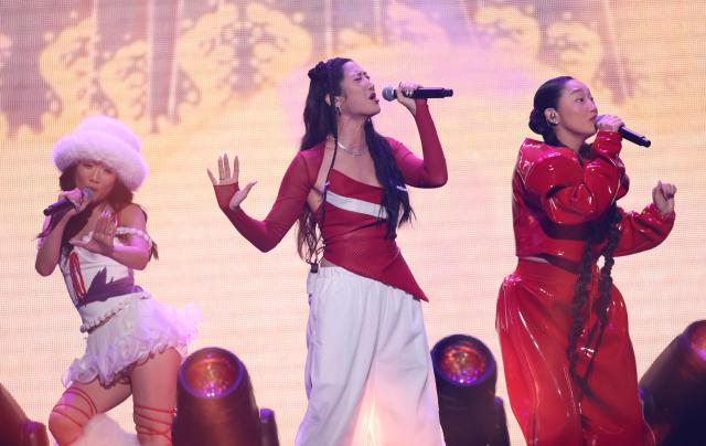 (L-R) Singers Rei Ami, Ejae and Audrey Nuna from the band HUNTR/X perform on stage during the KIIS FM's iHeartRadio Jingle Ball 2025 at the Inuit Dome in Inglewood, California on December 4, 2025. (Photo by Michael Tran / AFP)