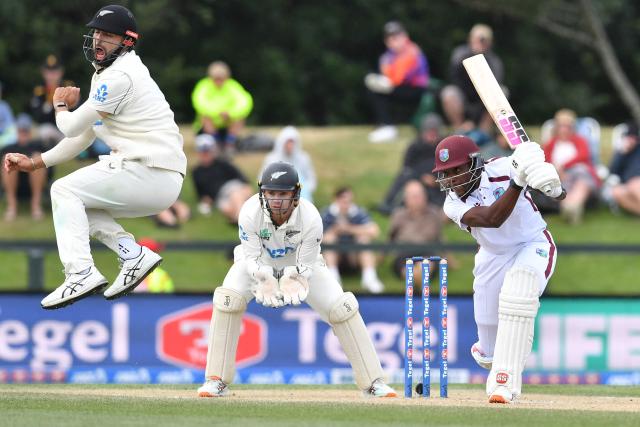 New Zealand's Daryl Mitchell (L) reacts as West Indies' Justin Greaves (R) plays a shot during day five of the first Test cricket match between New Zealand and West Indies at Hagley Oval in Christchurch on December 6, 2025. (Photo by Sanka Vidanagama / AFP)