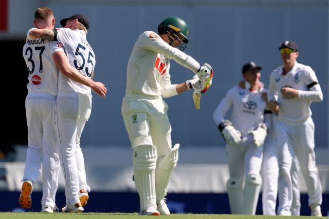 England’s captain Ben Stokes (2nd L) celebrates with Gus Atkinson (L) after he dismissed Australia’s Alex Carey (C) on day three of the second Ashes cricket Test match between Australia and England at The Gabba in Brisbane on December 6, 2025. (Photo by DAVID GRAY / AFP)