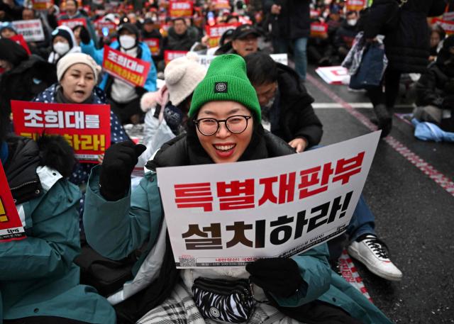 A protester holds a placard reading "Establish a special court!" during a rally marking the first anniversary of South Korean ousted president Yoon Suk Yeol's declaration of martial law, near the National Assembly in Seoul on December 6, 2025. (Photo by Jung Yeon-je / AFP)
