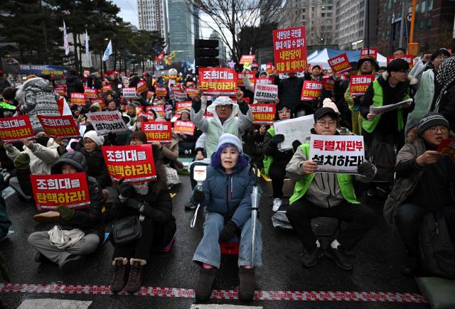 Protesters attend a rally marking the first anniversary of South Korean ousted president Yoon Suk Yeol's declaration of martial law, near the National Assembly in Seoul on December 6, 2025. (Photo by Jung Yeon-je / AFP)