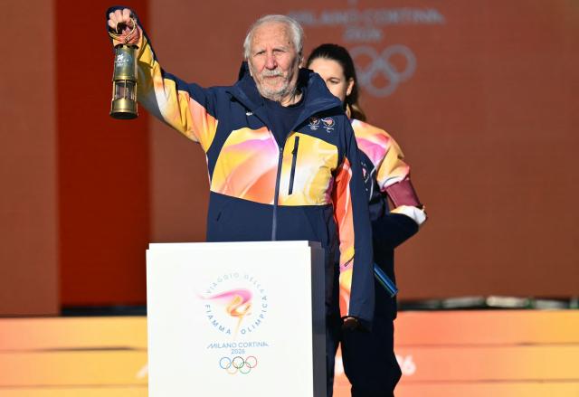 Former athlete Italy's Giancarlo Peris holds the torch at the Stadio dei Marmi (Stadium of the Marbles) one of four stadiums located in the Foro Italico sports complex during the Torch Relay to Milano Cortina 2026 Olympic Games, in Rome on December 6, 2025. (Photo by Alberto PIZZOLI / AFP)