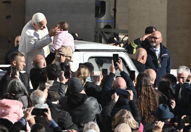 Pope Leo XIV caresses a baby from his popemobile as he arrives to leads the Jubilee Audience at St Peter's Square in The Vatican on December 6, 2025. (Photo by Isabella BONOTTO / AFP)