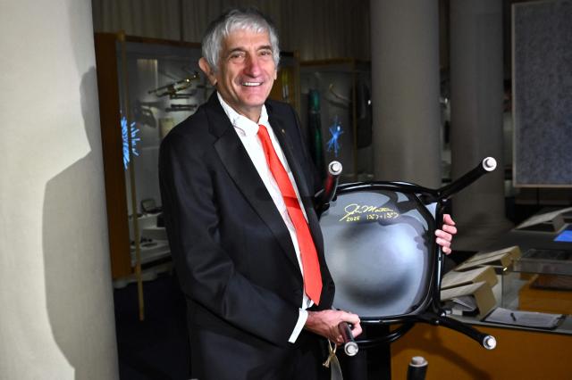 Nobel Prize in Physics 2025 laureate US physicist John M Martinis poses with a chair which he signed at the Nobel Museum in Stockholm on December 6, 2025. (Photo by Claudio BRESCIANI / TT News Agency / AFP) / Sweden OUT