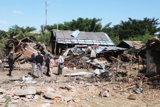 People inspect their damaged home after bombardments carried out by Myanmar's military in Tabayin, in Myanmar’s Sagaing Region on December 6, 2025. Eighteen people were killed in an airstrike on a town in central Myanmar, according to a local official, a rescue worker and two residents who spoke to AFP on December 6. (Photo by AFP)