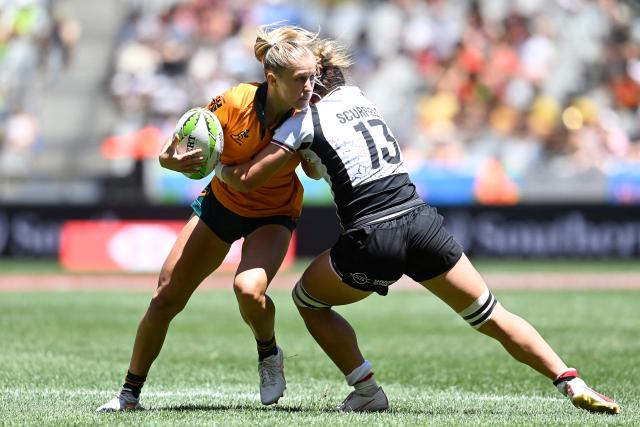Australia's Mackenzie Davis (L) is tackled by Canada's Krissy Scurfield (R) during the pool B HSBC World Rugby Sevens Series women's rugby match between Australia and Canada at the DHL stadium in Cape Town on December 6, 2025. (Photo by Rodger Bosch / AFP)