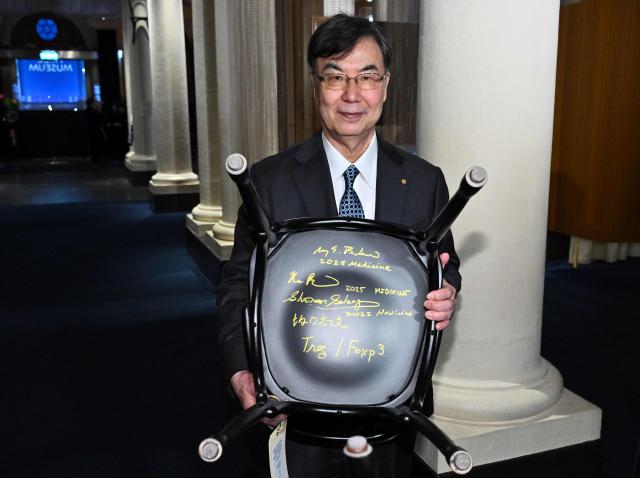 Shimon Nobel Prize in Physiology or Medicine 2025 laureate Japanese immunologist Shimon Sakaguchi poses after signing a Nobel chair at the Nobel Museum in Stockholm on December 6, 2025. (Photo by Claudio BRESCIANI / TT News Agency / AFP) / Sweden OUT
