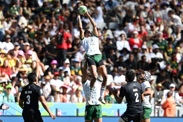 South Africa's Tristan Leyds jumps to catch a high ball during the pool A HSBC World Rugby Sevens Series men's rugby match between New Zealand and South Africa at the DHL stadium in Cape Town on December 6, 2025. (Photo by Rodger Bosch / AFP)