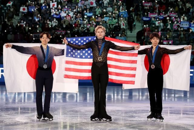 Gold medalist USA's Ilia Malinin (C), silver medalist Japan's Yuma Kagiyama (L) and bronze medalist Japan's Shun Sato pose after the award ceremony for the Senior Men Free Skating event at the ISU Grand Prix of Figure Skating final in Nagoya on December 6, 2025. (Photo by PAUL MILLER / AFP)