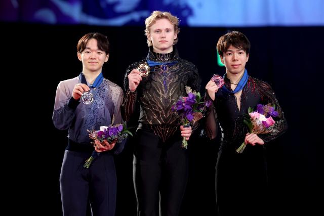 Gold medalist USA's Ilia Malinin (C), silver medalist Japan's Yuma Kagiyama (L) and bronze medalist Japan's Shun Sato pose during the award ceremony for the Senior Men Free Skating event at the ISU Grand Prix of Figure Skating final in Nagoya on December 6, 2025. (Photo by PAUL MILLER / AFP)