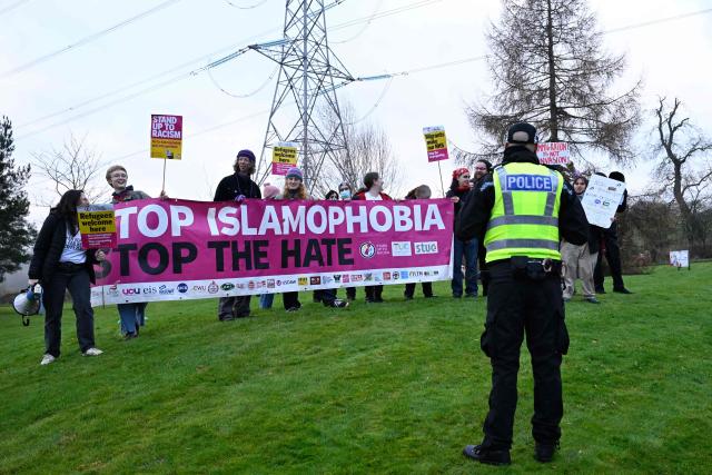 Demonstrators protest against Reform UK's leader, Nigel Farage, near the venue of a rally being held by the political party, in Falkirk, Scotland, on December 6, 2025. Populist leader Nigel Farage rallied supporters in Scotland on Saturday, bidding to build on unexpectedly strong backing for his anti-immigration Reform UK party five months before elections to its devolved parliament. (Photo by Lesley Martin / AFP)