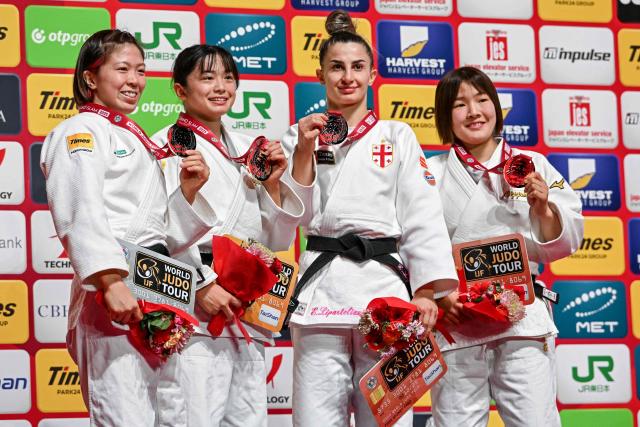 Gold medalist Japan's Akari Omori (2L), compatriot silver medalist Tamaoki Momo (L) with bronze medalists compatriot Mio Shirakane (R) and Georgia's Eteri Liparteliani (2R) pose on the podium after the women's under 57kg event at the Tokyo Grand Slam judo competition in Tokyo on December 6, 2025. (Photo by Toshifumi KITAMURA / AFP)