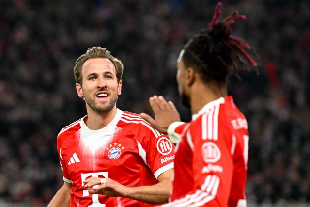 Bayern Munich's English forward #09 Harry Kane (L) celebrates with Bayern Munich's French midfielder #17 Michael Olise after scoring his side's 5th goal to complete his hat-trick during the German first division Bundesliga football match between VfB Stuttgart and Bayern Munich in Stuttgart on December 6, 2025. (Photo by THOMAS KIENZLE / AFP) / DFL REGULATIONS PROHIBIT ANY USE OF PHOTOGRAPHS AS IMAGE SEQUENCES AND/OR QUASI-VIDEO
