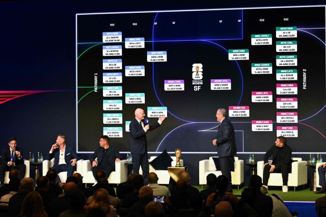 FIFA President Gianni Infantino (center-L) speaks as the screen displays the schedule during the FIFA World Cup 2026 official match schedule announcement in Washington, DC, on December 6, 2025. (Photo by Roberto SCHMIDT / AFP)
